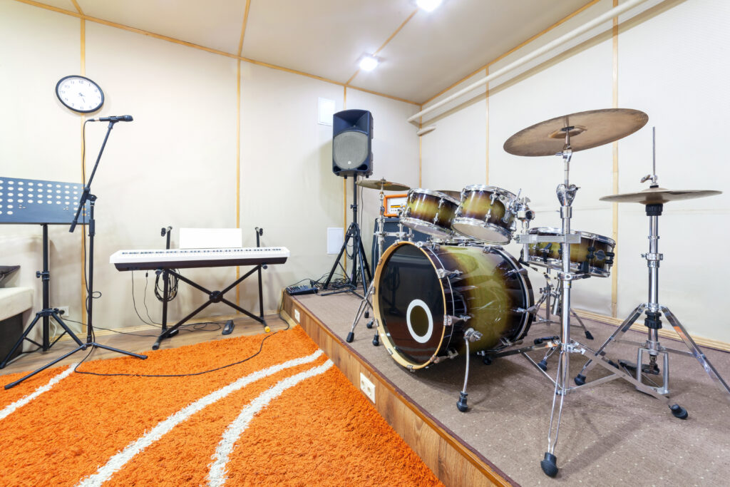 Music rehearsal space with drum kit and musical equipment.