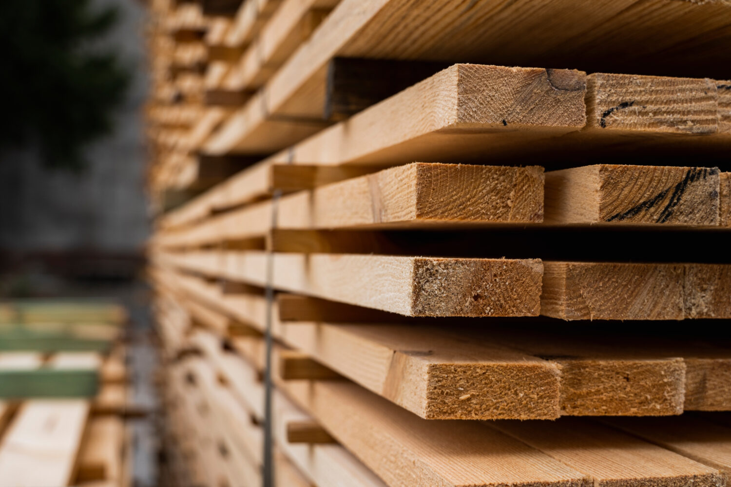 Piles of wooden boards in the sawmill, planking. Warehouse for sawing boards on a sawmill outdoors. Wood timber stack of wooden blanks construction material. Industry