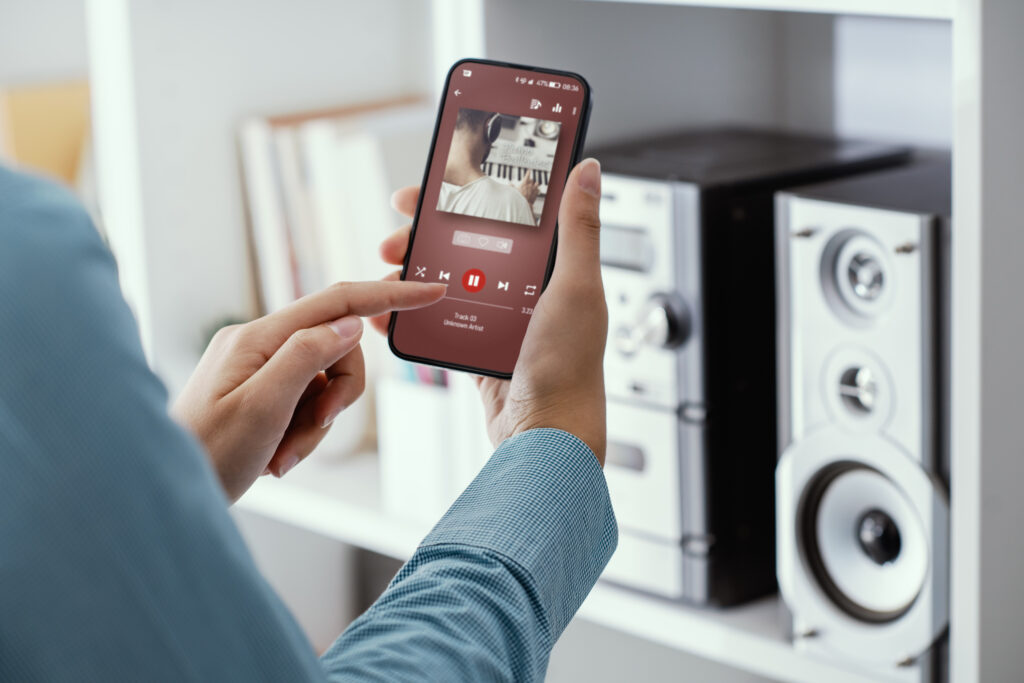 Woman playing music online on her stereo using her phone