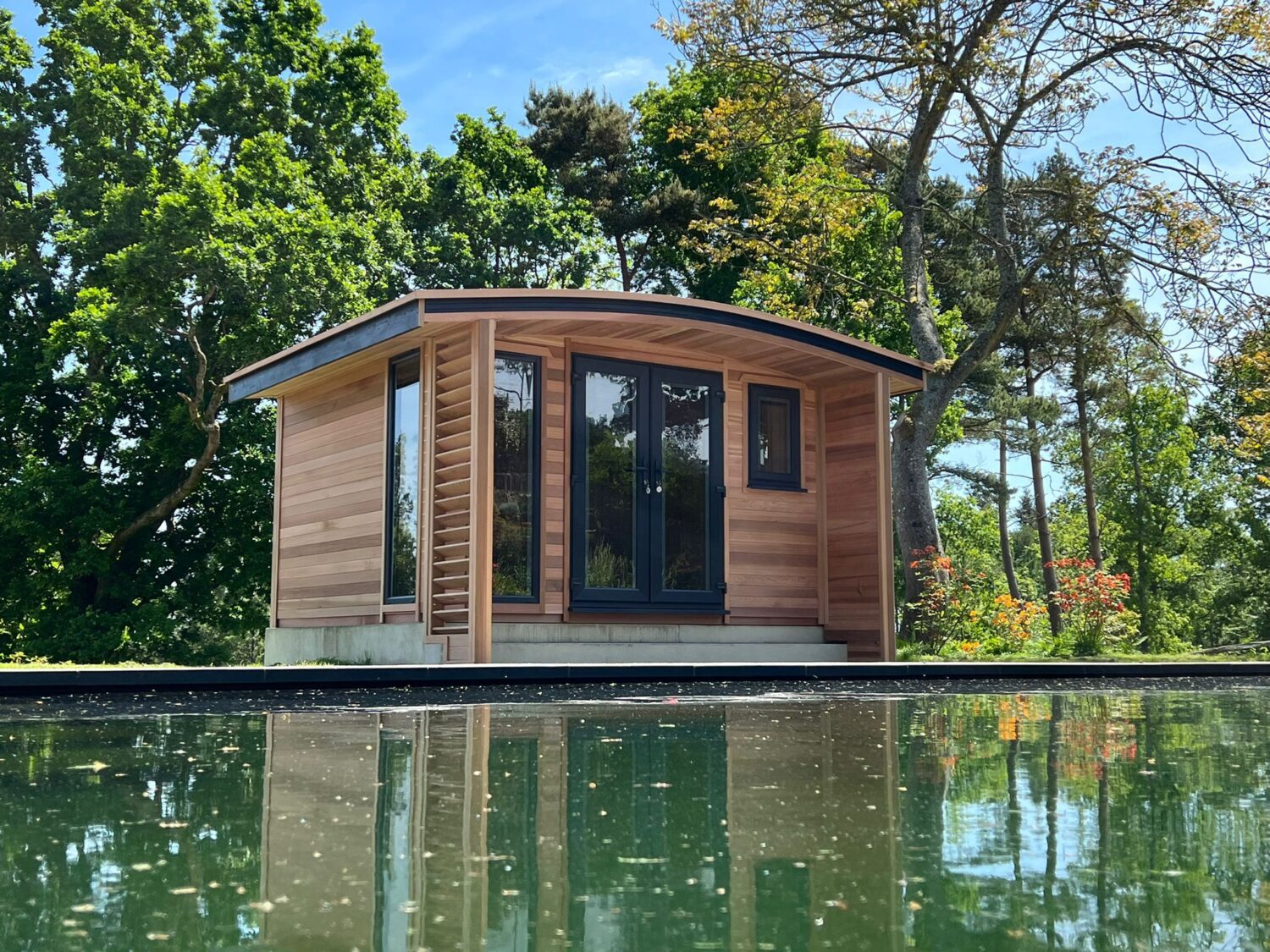 photo of a small garden room sitting by water