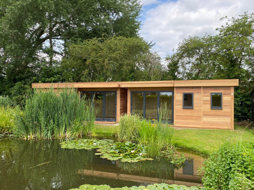 View of two Modern Garden Rooms over pond
