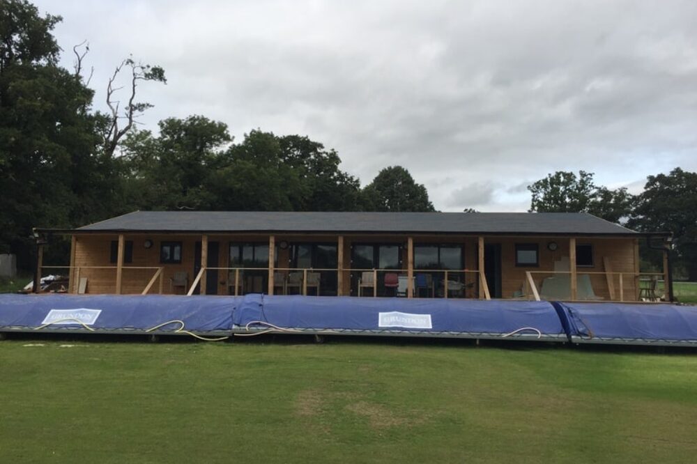 Cricket pitch with wooden clubhouse