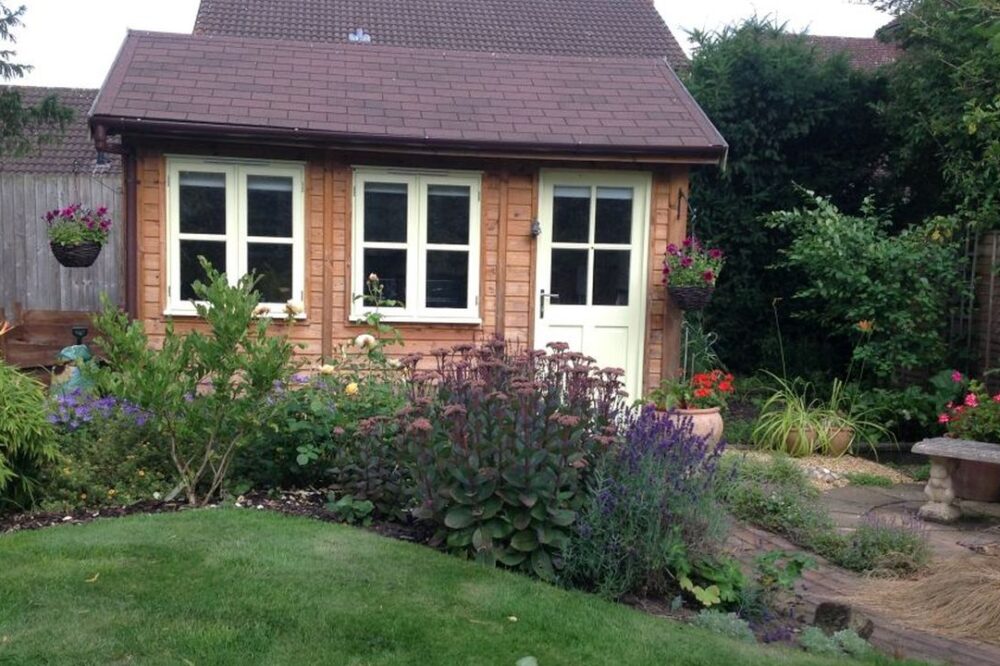 Traditional small garden room with white door and windows